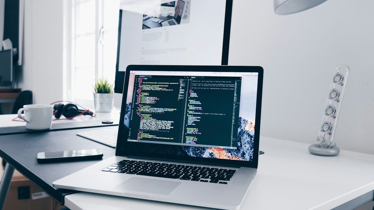 Web developer testing a website on a laptop in a modern workspace